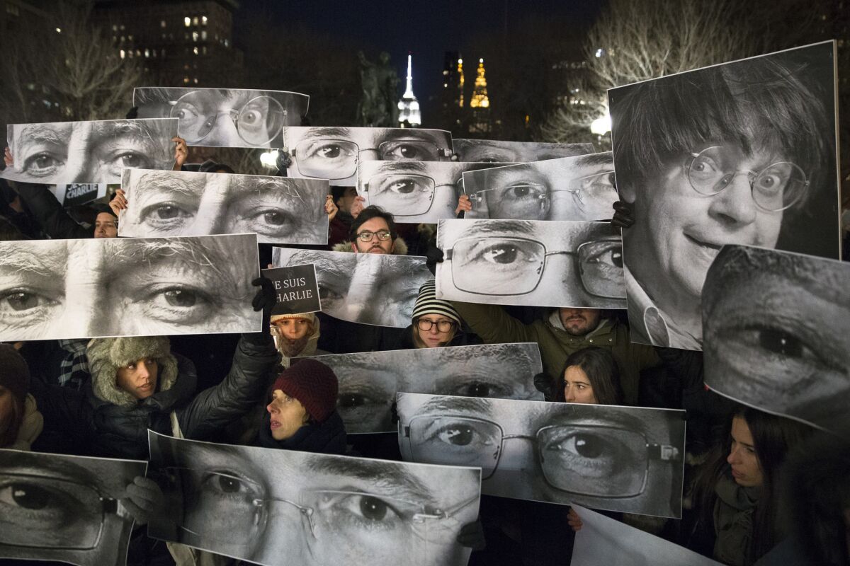 Mourners in New York City hold signs depicting victims' eyes during a rally in support of Charlie Hebdo.