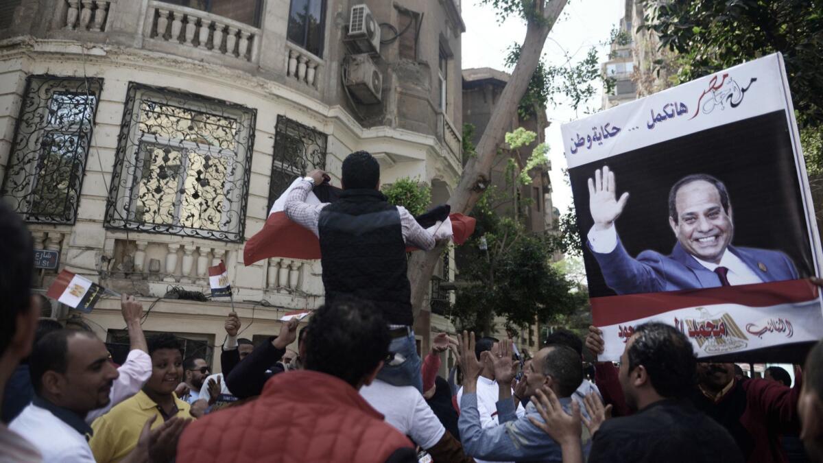 Supporters of Egyptian president Abdel Fattah Sisi dance outside a polling station in the Cairo district of Zamalek on the first day of the presidential election, March 26, 2018.