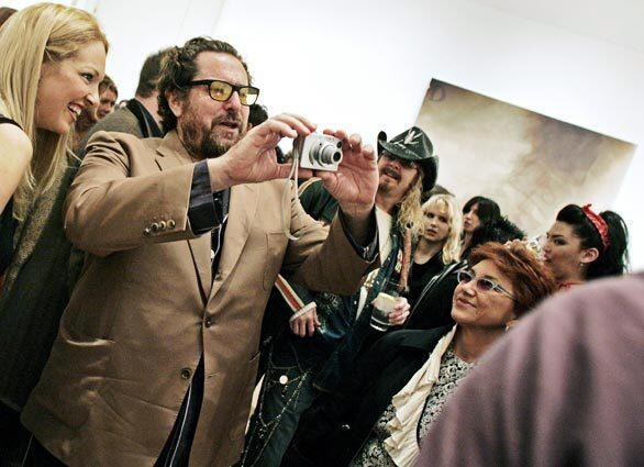 Artist-director Julian Schnabel snaps a photo as he is mobbed by well-wishers during the opening Thursday of his art exhibition at the Gagosian Gallery in Beverly Hills. He is up for an Oscar as director of "The Diving Bell and the Butterfly."