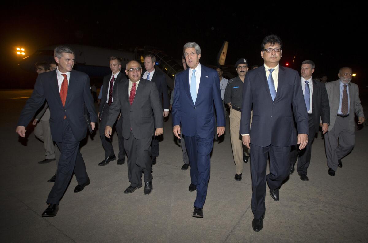 Secretary of State John F. Kerry, center, walks with U.S. Ambassador to Pakistan Richard Olson, left, and Pakistani officials upon his arrival in Islamabad.