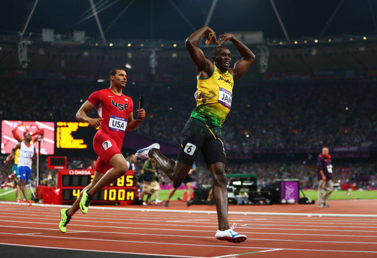 Usain Bolt of Jamaica celebrates crossing the finish line ahead of Ryan Bailey of the United States to win gold and set a world record of 36.84 during the men's 400-meter relay final at the London Olympics.