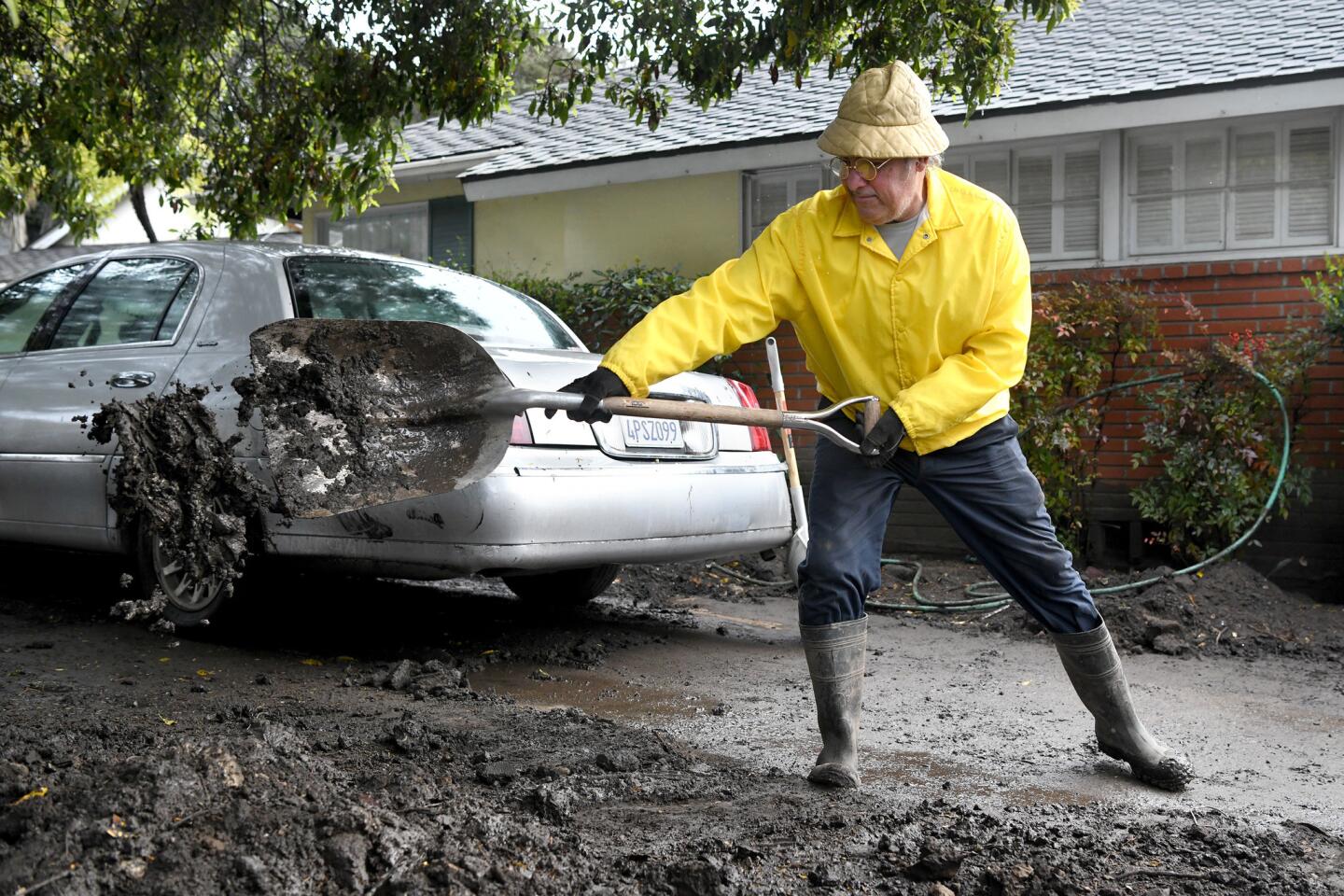 Mark Vance shovels his driveway March 2 after new rains loosened mud deposited by January's storm in front of his house on Olive Mill Road in Montecito.
