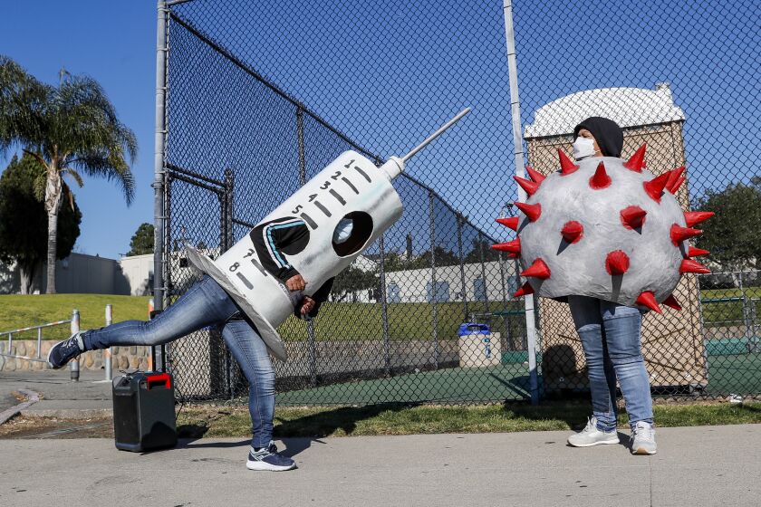 San Juan Capistrano, CA, Friday, February 25, 2022 - At least once a week, Socorro Juarez dresses up as a vaccine syringe and dances around with Rosa Cardona, dressed as a Corona virus, trying to convince fellow Latinos to get vaccinated and boosted. (Robert Gauthier/Los Angeles Times)