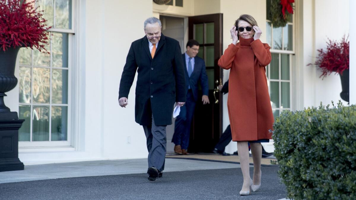 House Minority Leader Nancy Pelosi of California and Senate Minority Leader Sen. Chuck Schumer of New York walk out of the White House following a meeting with President Trump in Washington on Dec. 11.