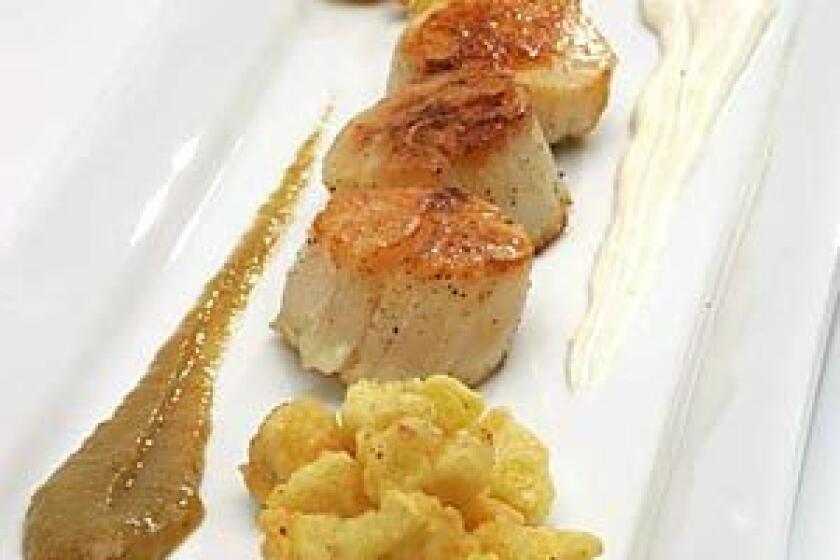 A SOPHISTICATED SIDE: Cauliflower beignets set off sauteed sea scallops and golden raisin puree spiked with three kinds of ground peppercorns.