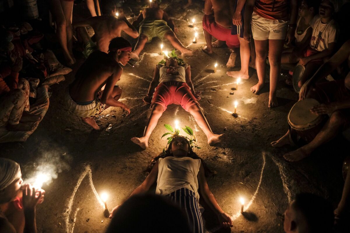 Followers of Maria Lionza's cult practice a ritual at Sorte Mountain in Venezuela's Yaracuy state, early Tuesday, Oct. 12, 2021, one year after the annual pilgrimage was cancelled due to COVID-19 restrictions. Along with Santeria, Venezuela is home to other folk religions, such as the sect surrounding the Indian goddess Maria Lionza, an indigenous woman who according to tradition was born on Sorte Mountain and whose cult has spread to Colombia, Panama, Puerto Rico, Dominican Republic, and Central America. (AP Photo/Matias Delacroix)