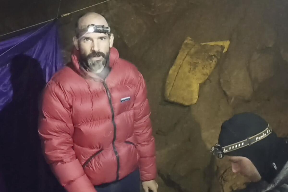 In this screen grab from video, American caver Mark Dickey, 40, talks to camera next to a colleague inside the Morca cave near Anamur, southern Turkey, Thursday, Sept. 7, 2023. Turkish and international cave rescue experts are working to save an American speleologist trapped at a depth of more than 1,000 meters (3,280 feet) in a cave in southern Turkey after he became ill. (Turkish Government Directorate of Communications via AP)