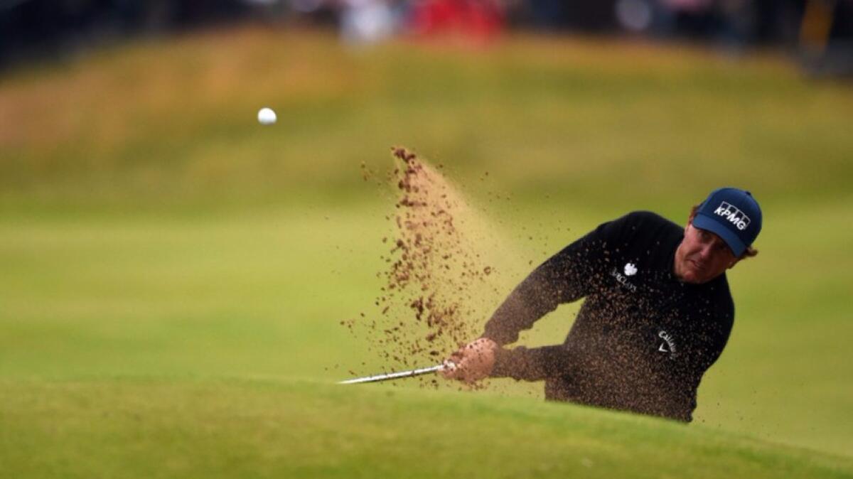 Phil Mickelson plays from a green-side bunker during the third round of the British Open at Royal Troon on July 16.