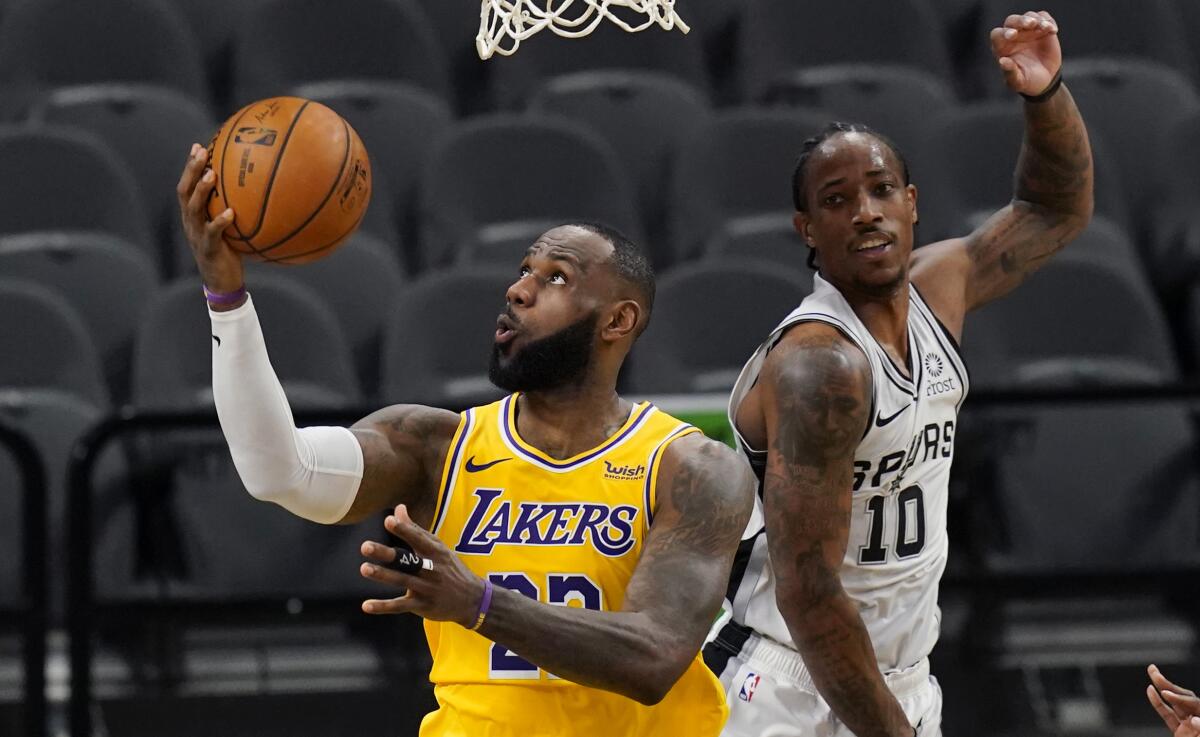 Lakers forward LeBron James scores past San Antonio Spurs guard DeMar DeRozan.