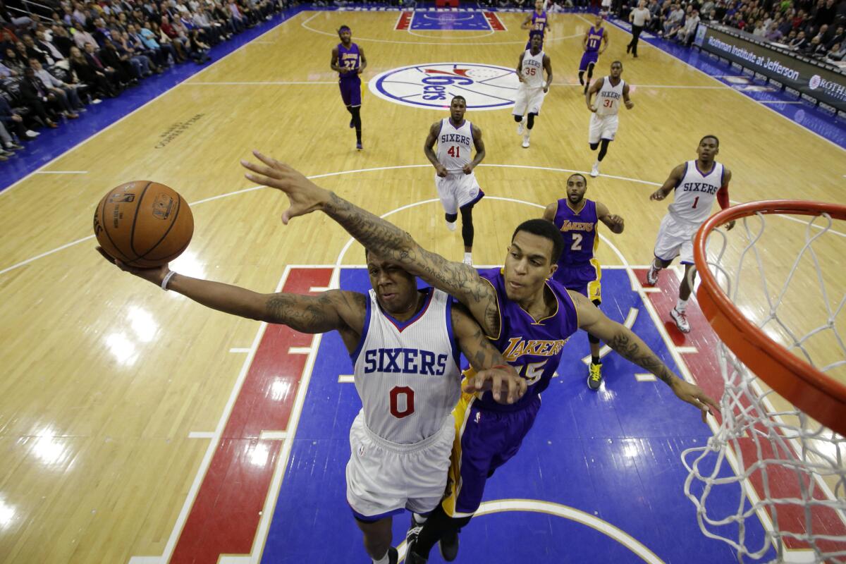 76ers guard Isaiah Canaan tries to avoid the outstretched limb of Lakers guard Jabari Brown on a fastbreak attempt in the second half.