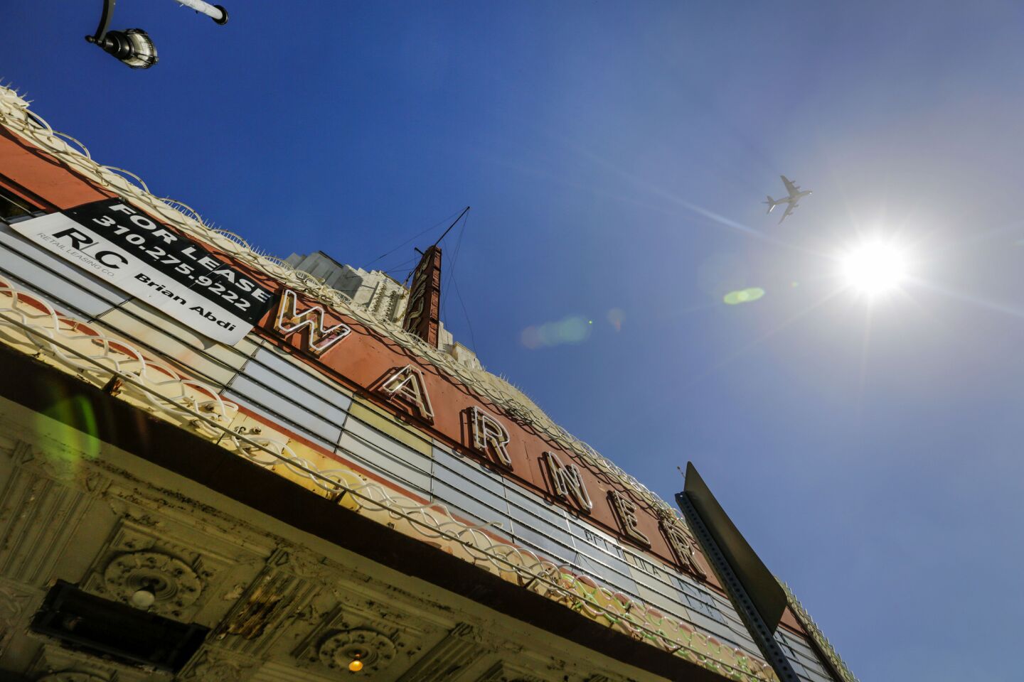 A "for lease" sign hangs on the Warner theater on Pacific Boulevard in Huntington Park.
