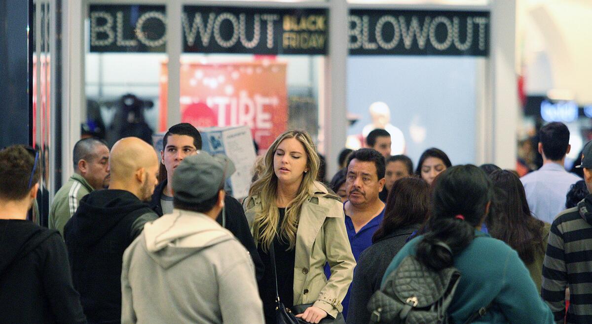 Shoppers work their way through the crowd on Black Friday at the Glendale Galleria on Friday, November 27, 2015.
