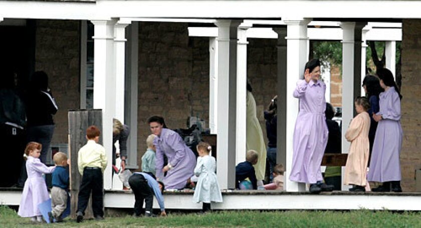 Women and children removed from a polygamist compound under investigation for child abuse gather on the porch of the Fort Concho National Historic Landmark in San Angelo, Texas, where they are being temporarily housed.
