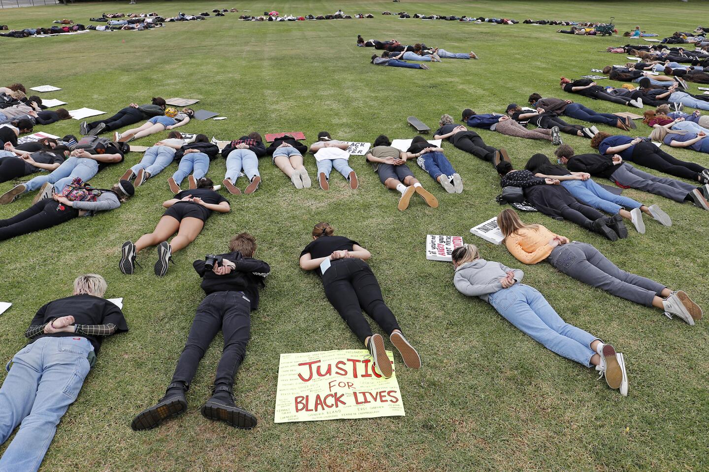 Students demonstrators lay on the ground with their arms crossed behind their backs for eight minutes and 46 seconds during a peaceful protest for George Floyd, Breonna Taylor and Black Lives Matter on Friday at Worthy Park in Huntington Beach.