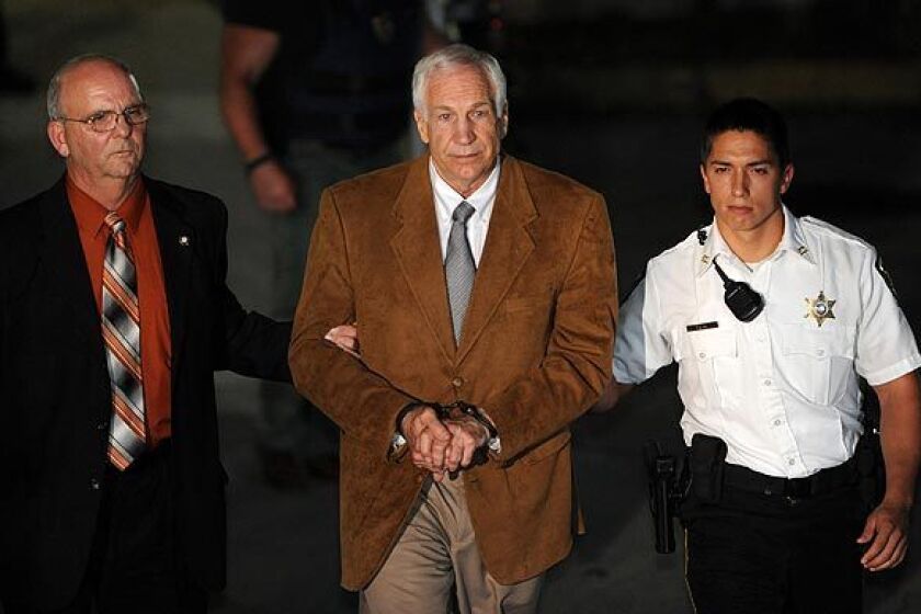Former Penn State assistant football coach Jerry Sandusky is escorted from the Bellefonte, Pa., courthouse in handcuffs after being found guilty on 45 counts in his child sexual abuse trial.