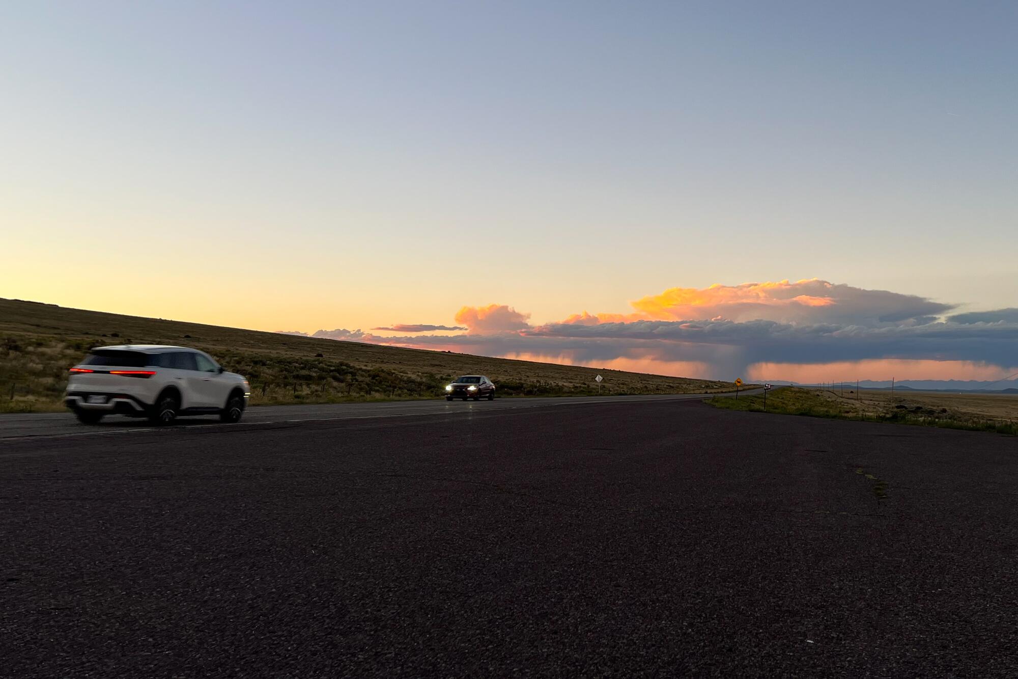 Vehicles on a darkened road at sunset 