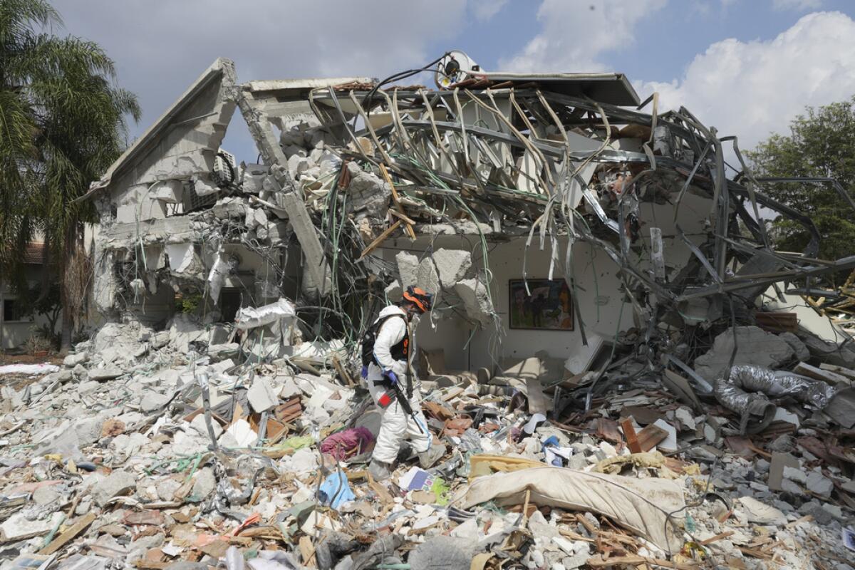 Un soldado israelí pasa junto a una vivienda destrozada