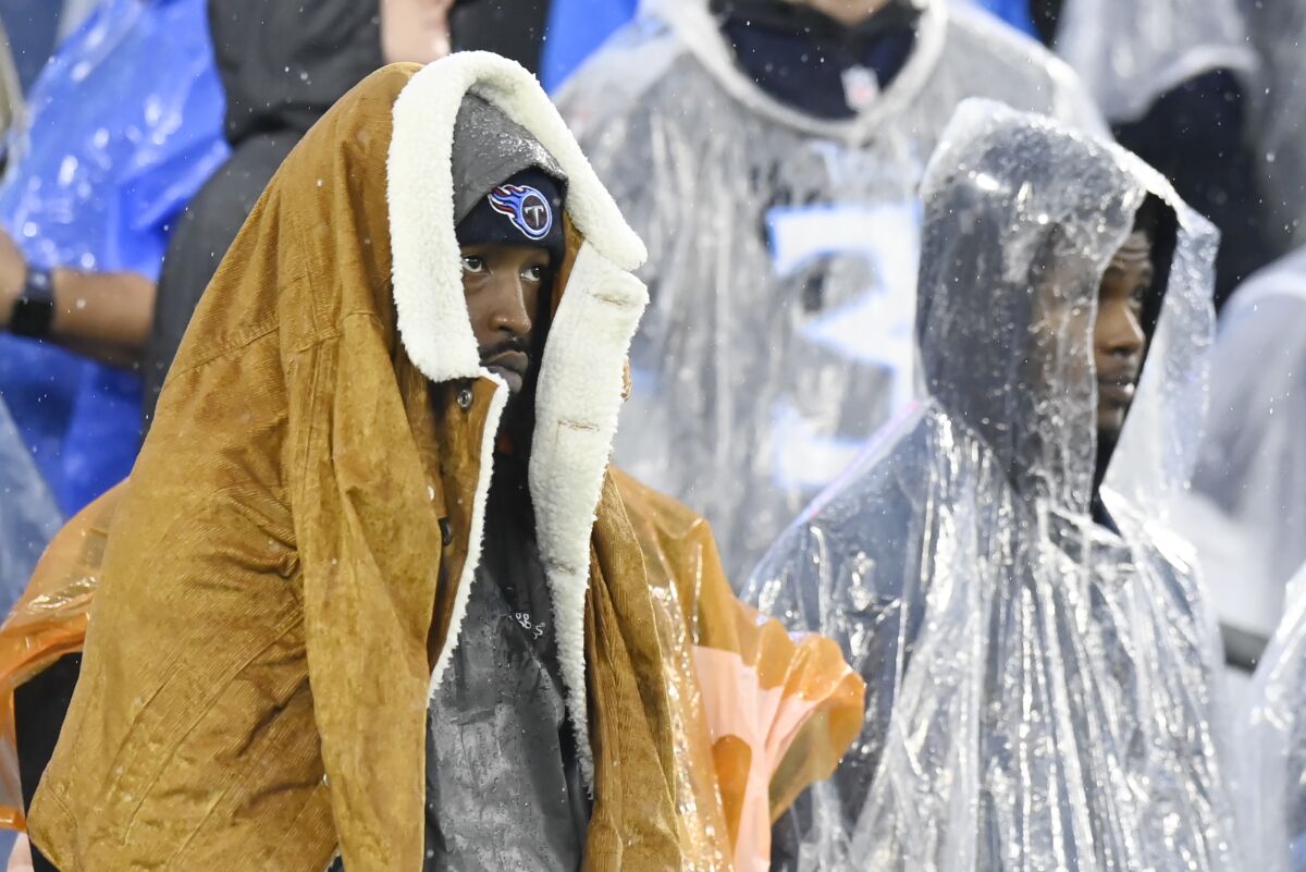 Tennessee Titans fans watch in the rain.