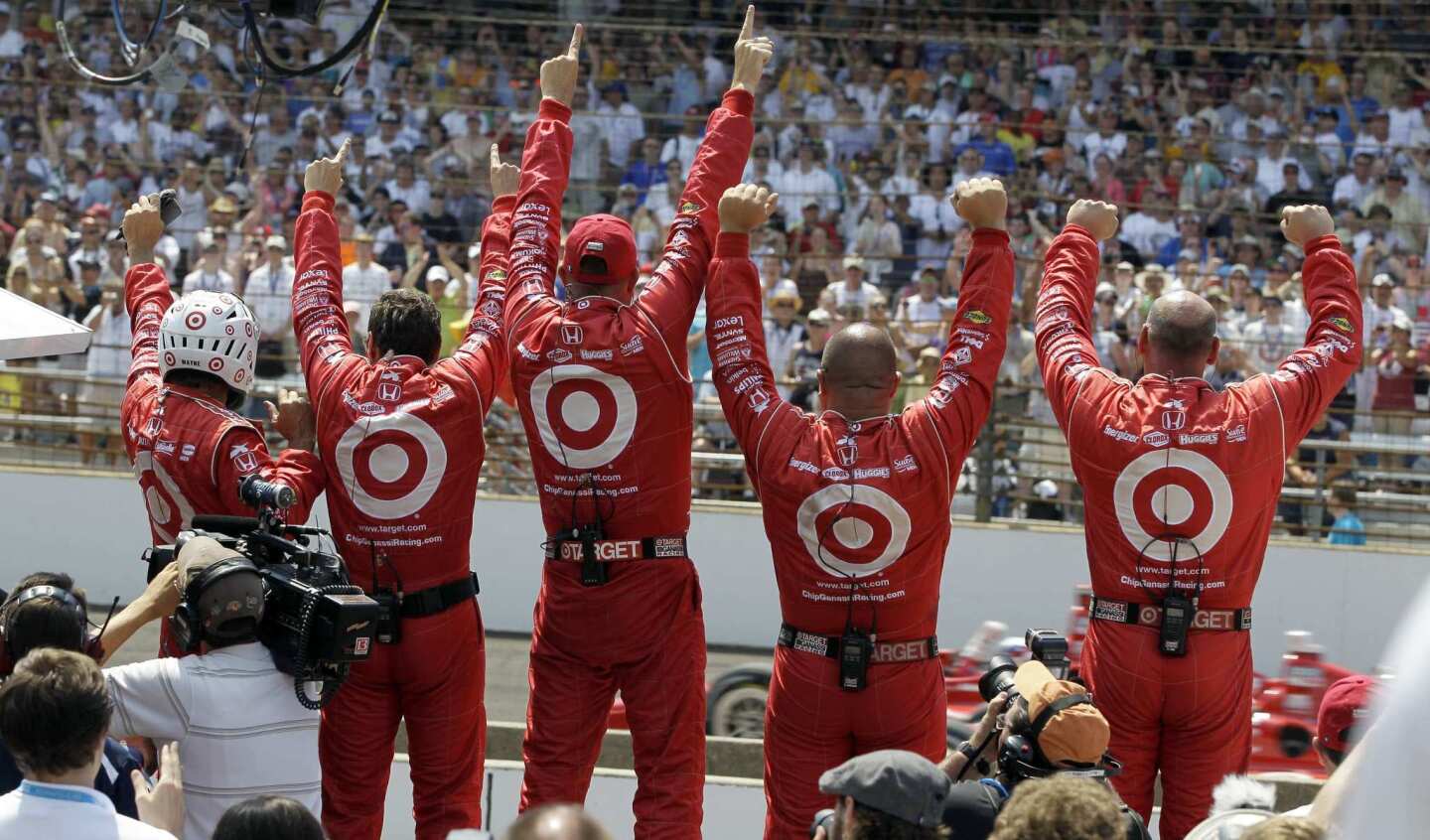 Crew members of driver Dario Franchitti celebrate as he wins the Indianapolis 500 on Sunday.