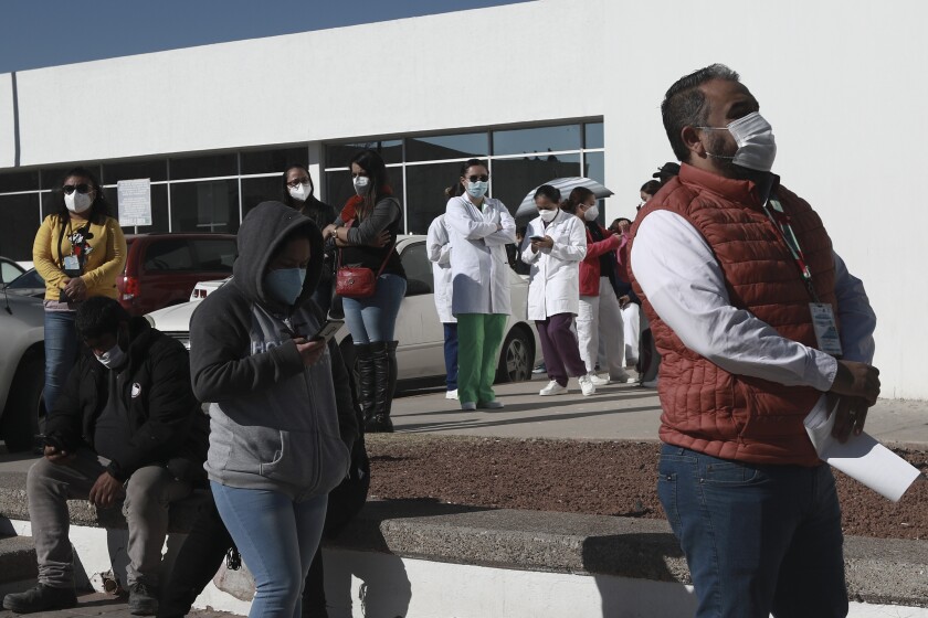 People wait in line outside a hospital in Ciudad Juarez, Mexico, to receive a vaccine.