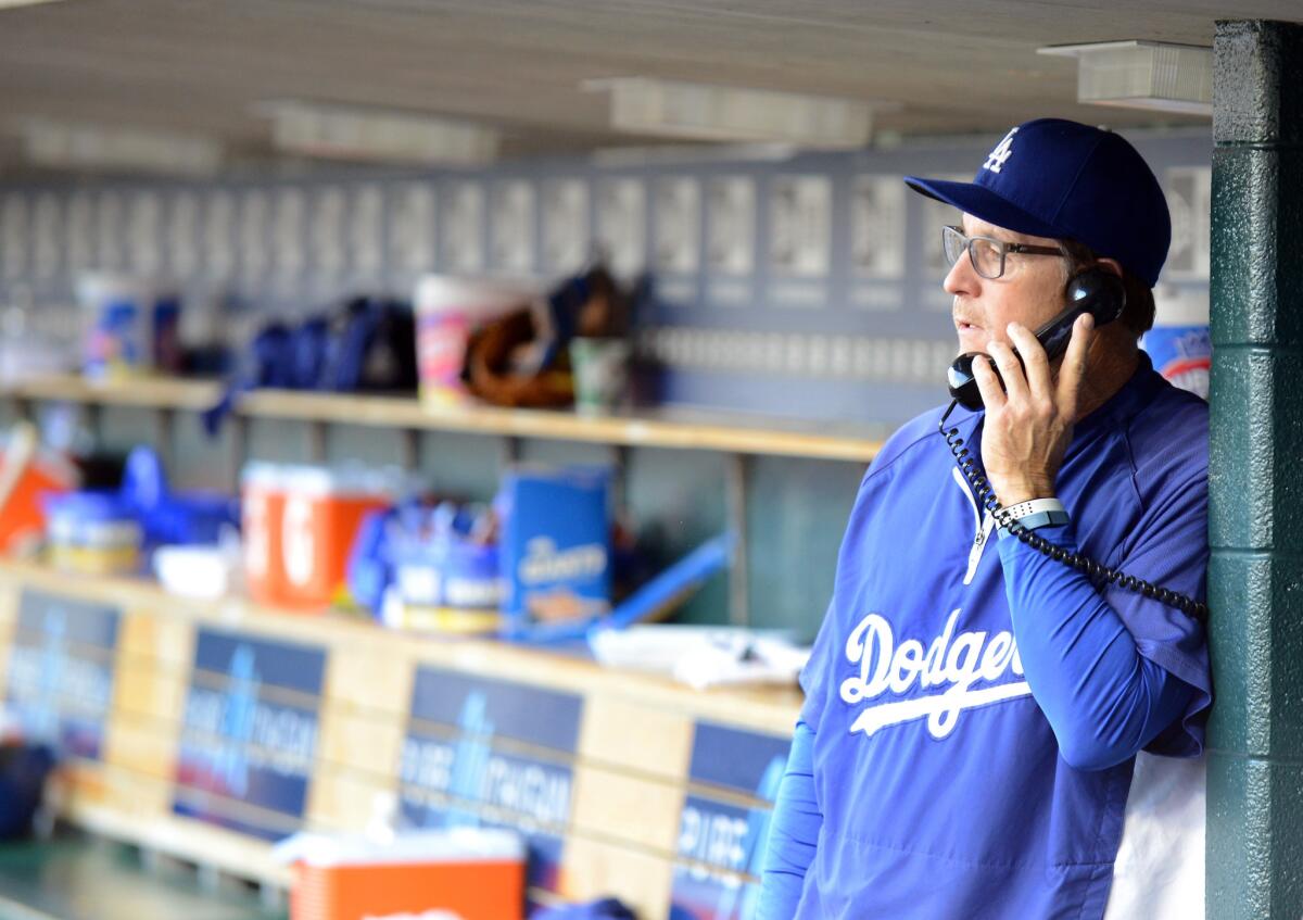 Dodgers bench coach Tim Wallach talks on the dugout phone during a July 8 game against Detroit.