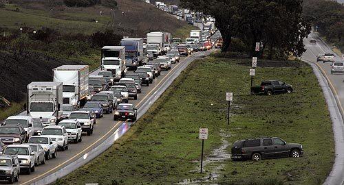 Two sport-utility vehicles are stuck in the mud while trying to make a U-turn across the median of northbound U.S. 101 in northern Santa Barbara County, where traffic came to a stop Wednesday morning after a tractor-trailer crashed just north of the Gaviota Pass tunnel. A winter storm settled over the Southland early Wednesday evening, closing Interstate 5 in the Grapevine area and beginning to soak the regions flatlands and valleys with an expected 2 inches of rain.