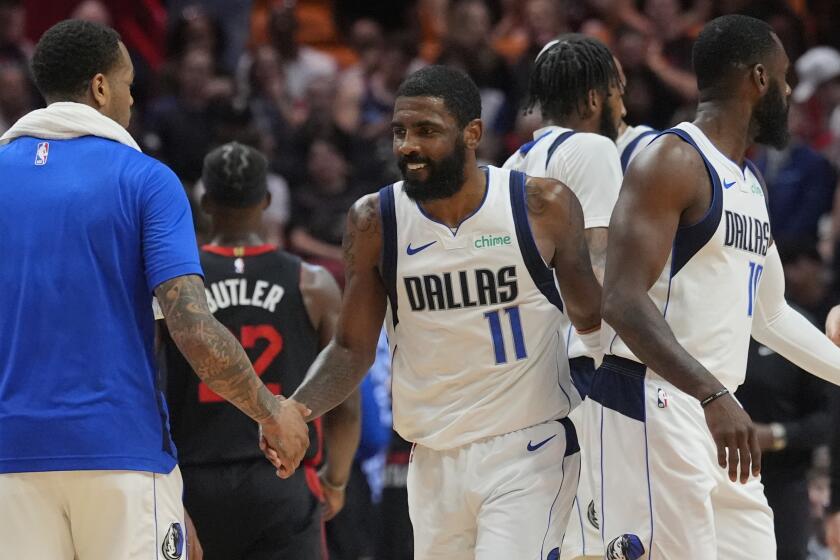 Kyrie Irving, de los Mavericks de Dallas, estrecha la mano de sus compañeros durante el encuentro del miércoles 10 de abril de 2024 ante el Heat de Miami (AP Foto/Marta Lavandier)