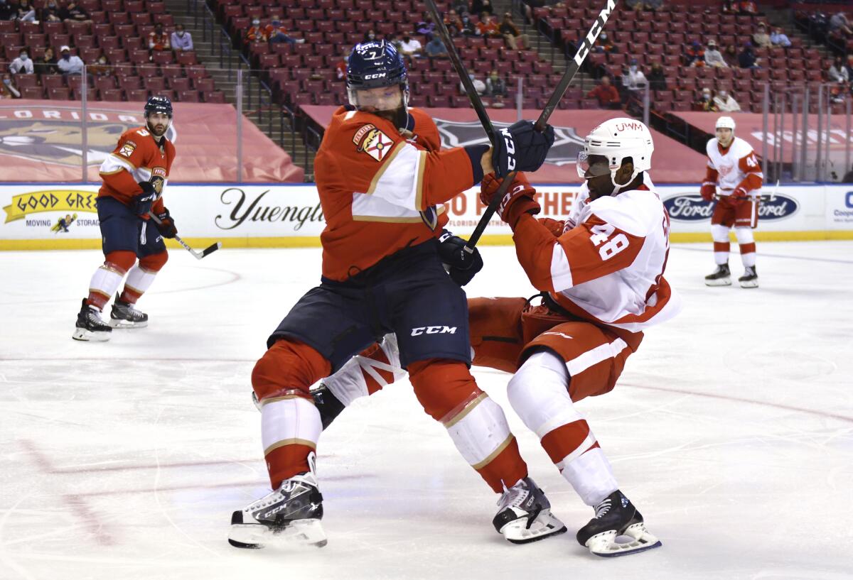 Florida Panthers defenseman Radko Gudas gets tied up with Detroit Red Wings left wing Givani Smith.