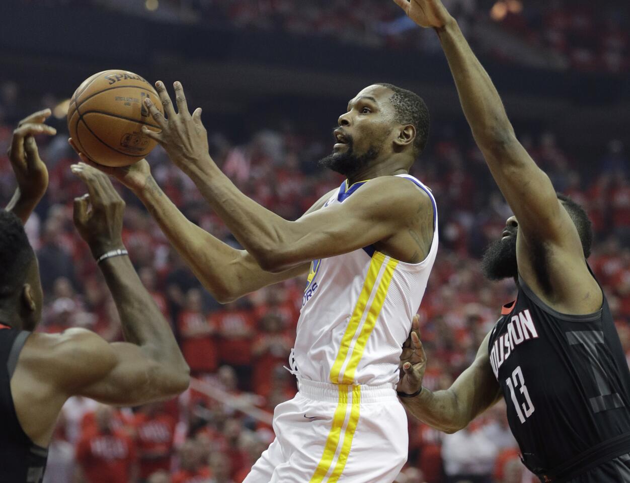 El alero de los Warriors de Golden State, Kevin Durant, ataca el aro y deja atrás a James Harden, de los Rockets de Houston, en la primera mitad del juego 1 de la Final de la Conferencia Oeste el lunes 14 de mayo de 2018 en Houston.