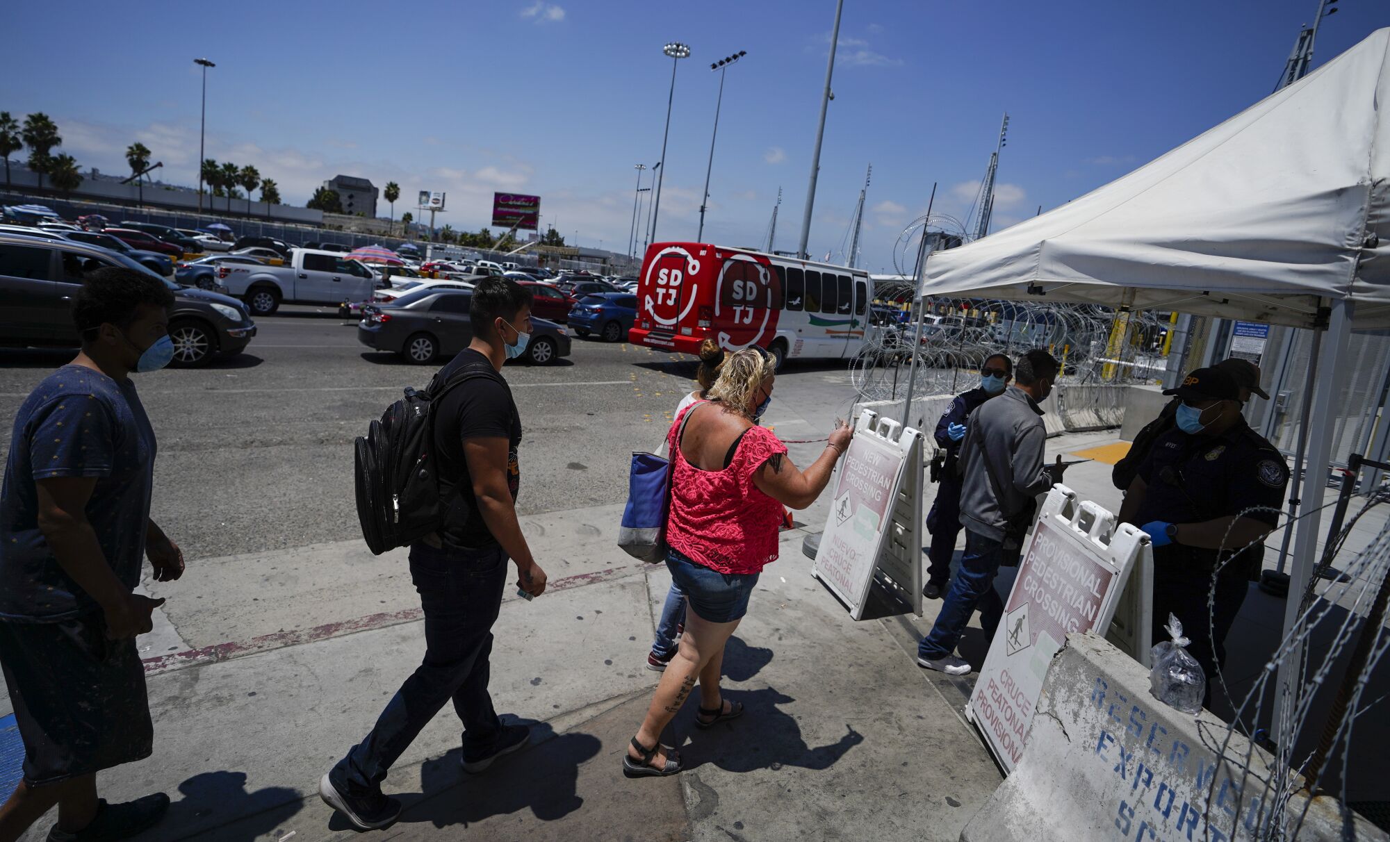 A line of people wait to enter pedestrian border crossing at San Ysidro Port of Entry