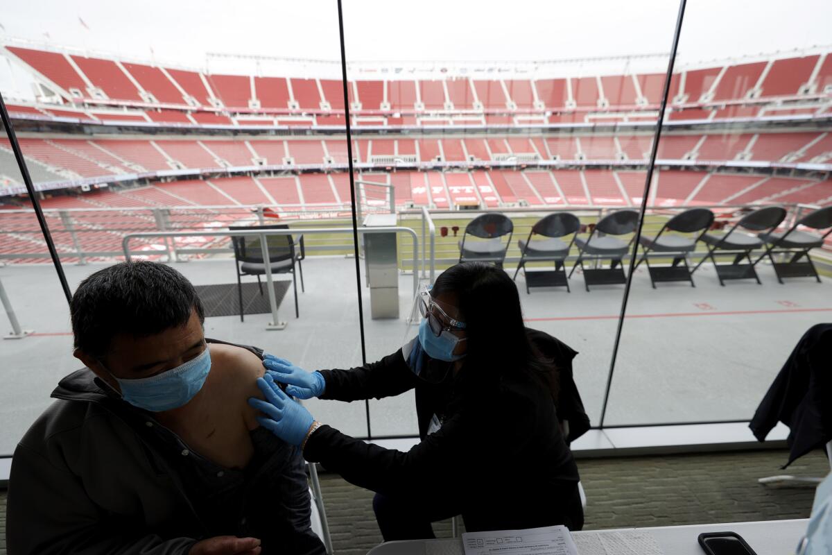 A man prepares to receive a dose of COVID-19 vaccine at Levi's Stadium in Santa Clara