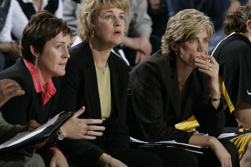 FILE - Iowa coach Lisa Bluder is flanked by assistant Jenni Fitzgerald, left, and associate head coach Jan Jensen, as they watch their team play during an NCAA college basketball game against Drake in Des Moines, Iowa, Friday, Dec. 22, 2006. Jenni Fitzgerald, who worked 32 years on Lisa Bluder's coaching staffs at Drake and Iowa, announced her retirement Wednesday, May 22, 2024. (Doug Wells/The Des Moines Register via AP, File)