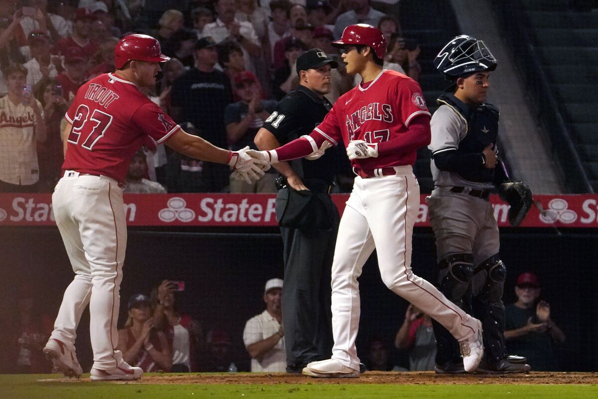 Angels' Mike Trout, left, congratulates Shohei Ohtani for hitting a home run against the New York Yankees on Aug. 29, 2022.