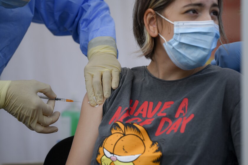 Alexandra Maiorescu gets a Pfizer BioNTech COVID-19 vaccine in Bucharest, Romania, Wednesday, June 2, 2021. Romania has started the vaccination campaign for children between the ages of 12 and 15. (AP Photo/Andreea Alexandru)