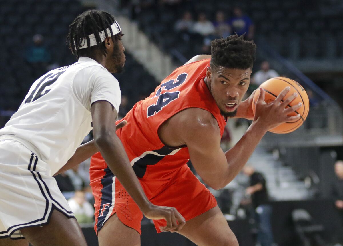 Cal State Fullerton forward E.J. Anosike (24) guards the ball from Long Beach State guard Jadon Jones (12) during the first half of an NCAA college basketball game for the championship of the Big West Conference men's tournament Saturday, March 12, 2022, in Henderson, Nev. (AP Photo/Ronda Churchill)