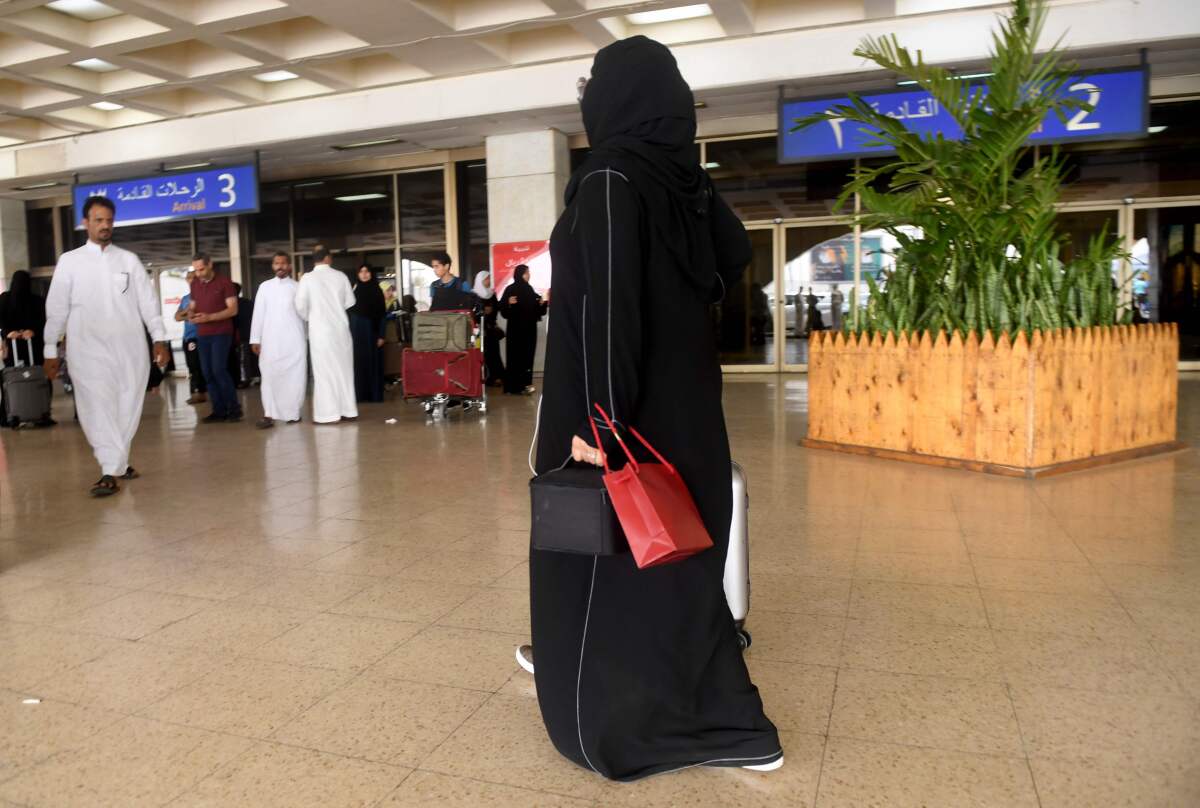 A Saudi woman rolls her suitcase at the departure hall of the Jeddah Airport on Aug. 6.