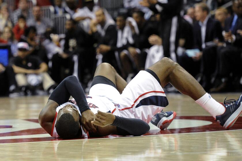Hawks forward Paul Millsap lies on the court after injuring his right shoulder in a game against the Nets on Saturday in Atlanta.