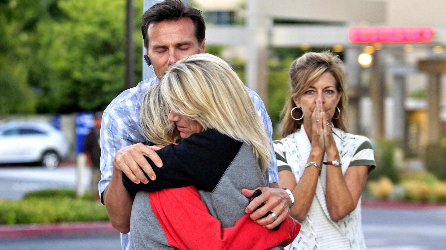 Connor's father, Devin, embraces his wife, Veronica, and daughter Sabrina, 18, after watching the helicopter transporting Connor's heart fly from Hoag Hospital in Newport Beach. At right is Connor's aunt Terri Mehrguth.