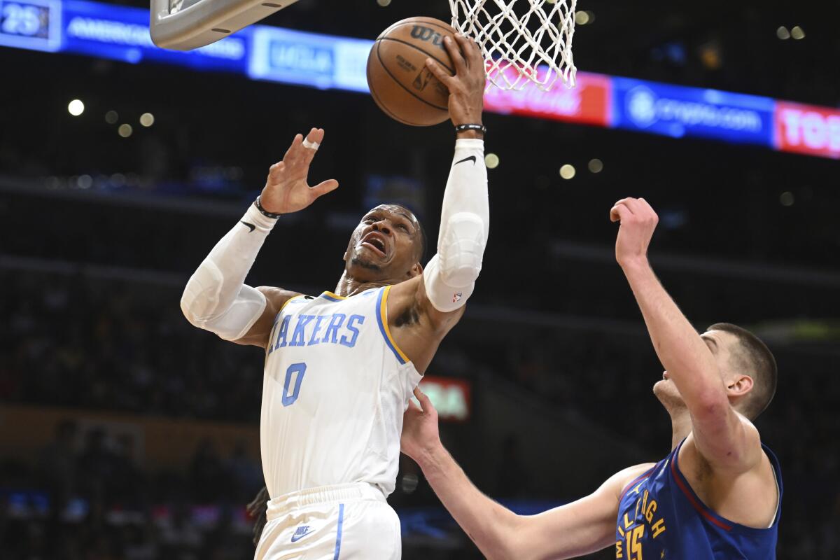 Lakers guard Russell Westbrook elevates for a layup against Nuggets center Nikola Jokic.