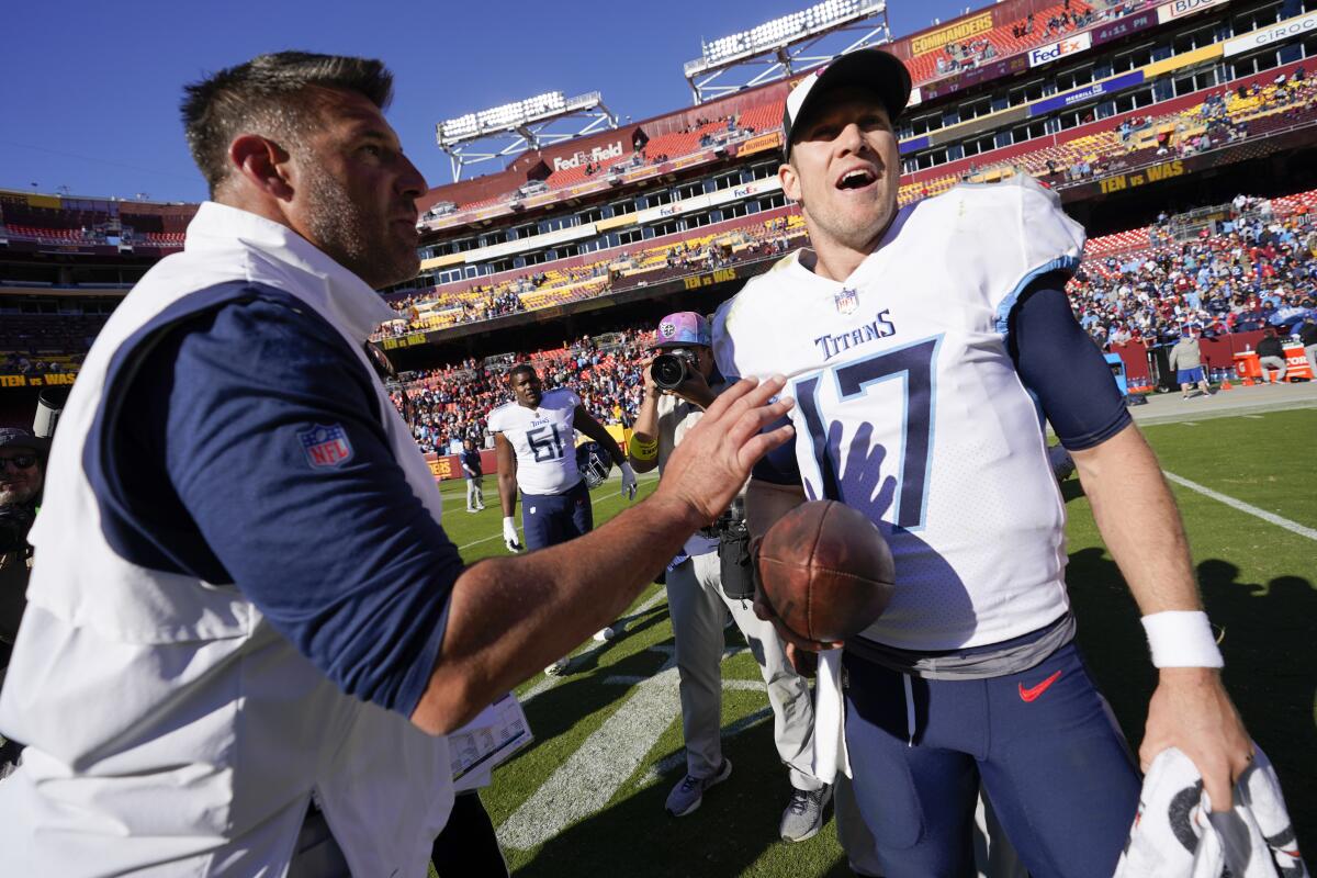 Tennessee Titans head coach Mike Vrabel, left, speaks with Titans quarterback Ryan Tannehill as he helps clear the field after officials put time back on the clock in the final moments of an NFL football game against the Washington Commanders, Sunday, Oct. 9, 2022, in Landover, Md. Tennessee won 21-17. (AP Photo/Alex Brandon)