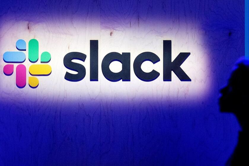 (FILES) In this file photo taken on April 24, 2019, an attendee walks by the companys logo during Slacks Frontiers conference at Pier 27 & 29 in San Francisco, California. - The workplace messaging startup Slack filed documents on April 26, 2019, to list its shares on the New York Stock Exchange, the latest of a group of richly valued tech enterprises to look to Wall Street. (Photo by NOAH BERGER / AFP)NOAH BERGER/AFP/Getty Images ** OUTS - ELSENT, FPG, CM - OUTS * NM, PH, VA if sourced by CT, LA or MoD **