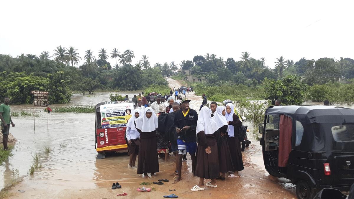Schoolchildren stand on a flood-damaged bridge