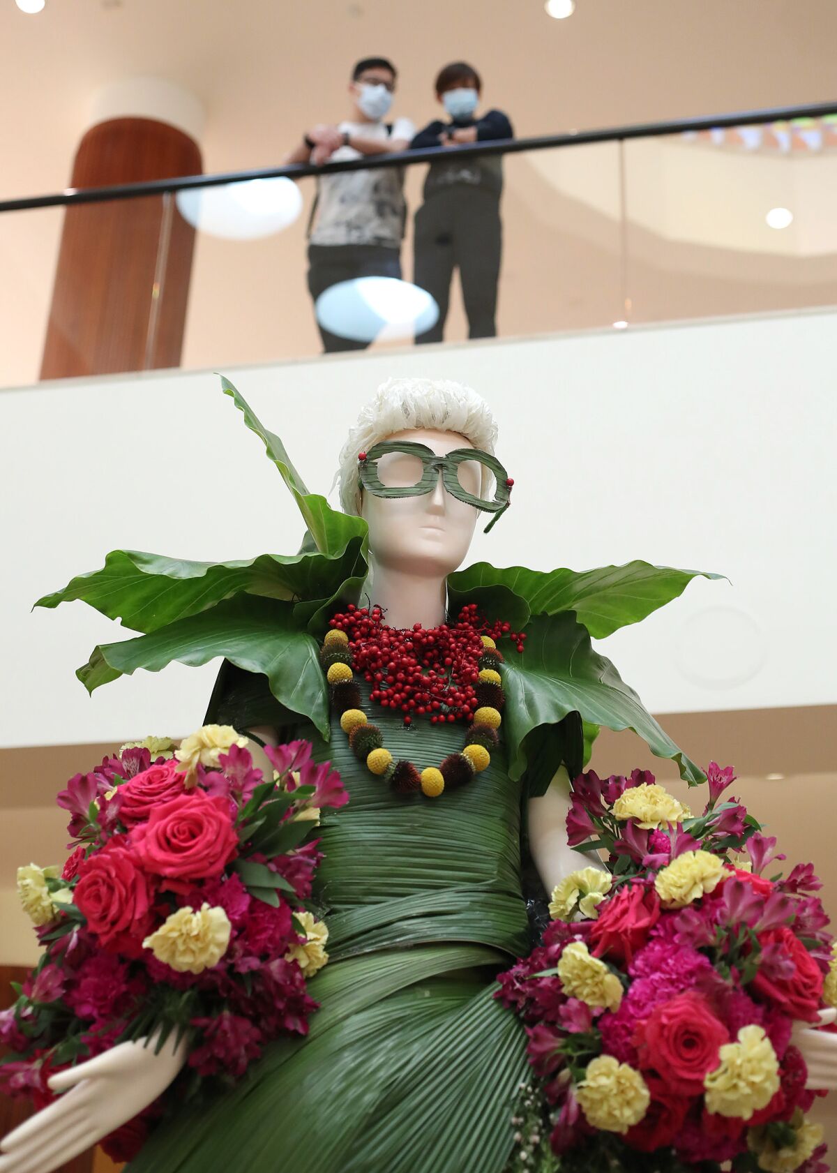 A figure of fashion icon Iris Apfel at the "Fleurs de Villes FEMMES" floral exhibit at South Coast Plaza's Jewel Court.