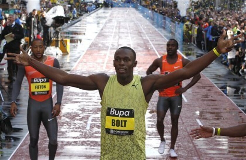 Jamaican athlete Usain Bolt, centre, celebrates after the 150m final during the Great Manchester City Games, in Manchester, England, Sunday, May 17, 2009. Usain Bolt ran the world's fastest 150 meters to win a soggy street sprint on Sunday that marked his return to action after a car crash left him requiring foot surgery. In windy Manchester, the triple Olympic champion ran down the English city's main thoroughfare in 14.35 seconds, breaking Donovan Bailey's 12-year-old mark of 14.99 in the rarely run 150. (AP Photo/ Jon Super)