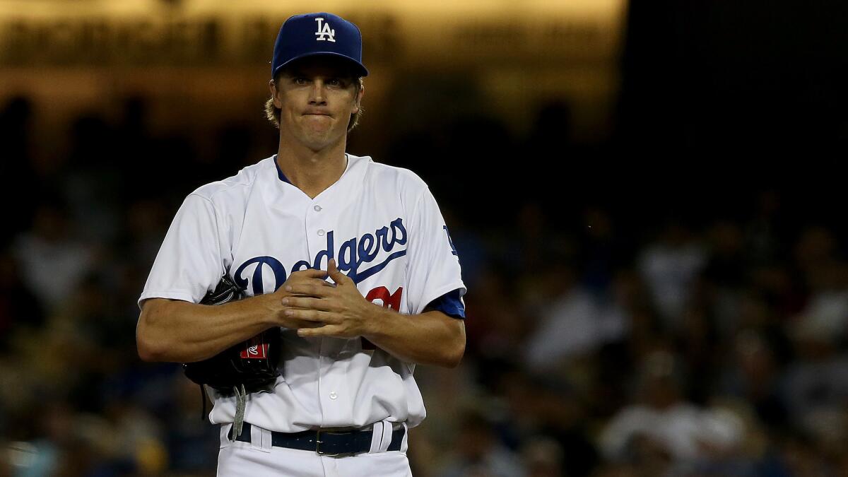 Dodgers starter Zack Greinke looks on during a game against the Atlanta Braves on July 30. Greinke will miss his scheduled start Thursday because of soreness in his elbow.
