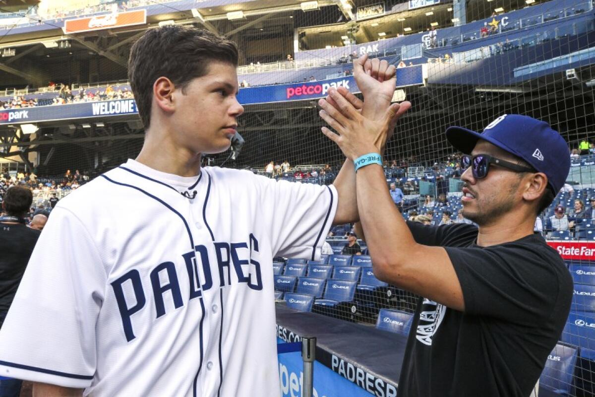Keane Webre-Hayes, 14, who was attacked by a great white shark last year, throws the ceremonial first pitch prior to the start of the Padres game against the Giants at Petco Park on Tuesday, July 2, 2019.
