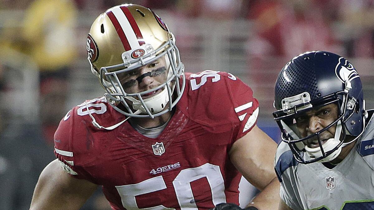 San Francisco 49ers linebacker Chris Borland, left, chases Seattle Seahawks wide receiver Doug Baldwin during a game on Nov. 27, 2014.