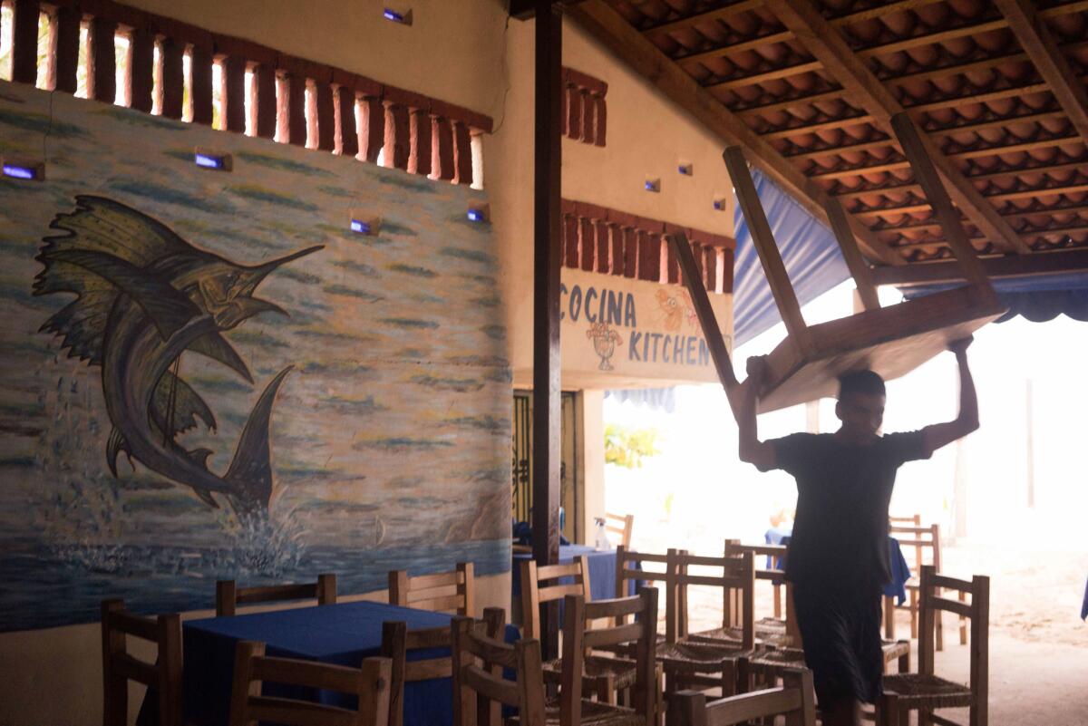 Un trabajador carga una mesa en un restaurante en la costa, en preparación para la llegada del huracán Patricia en el destino turístico de Puerto Vallarta, en México, el jueves 22 de octubre de 2015. (AP Foto/Cesar Rodriguez)