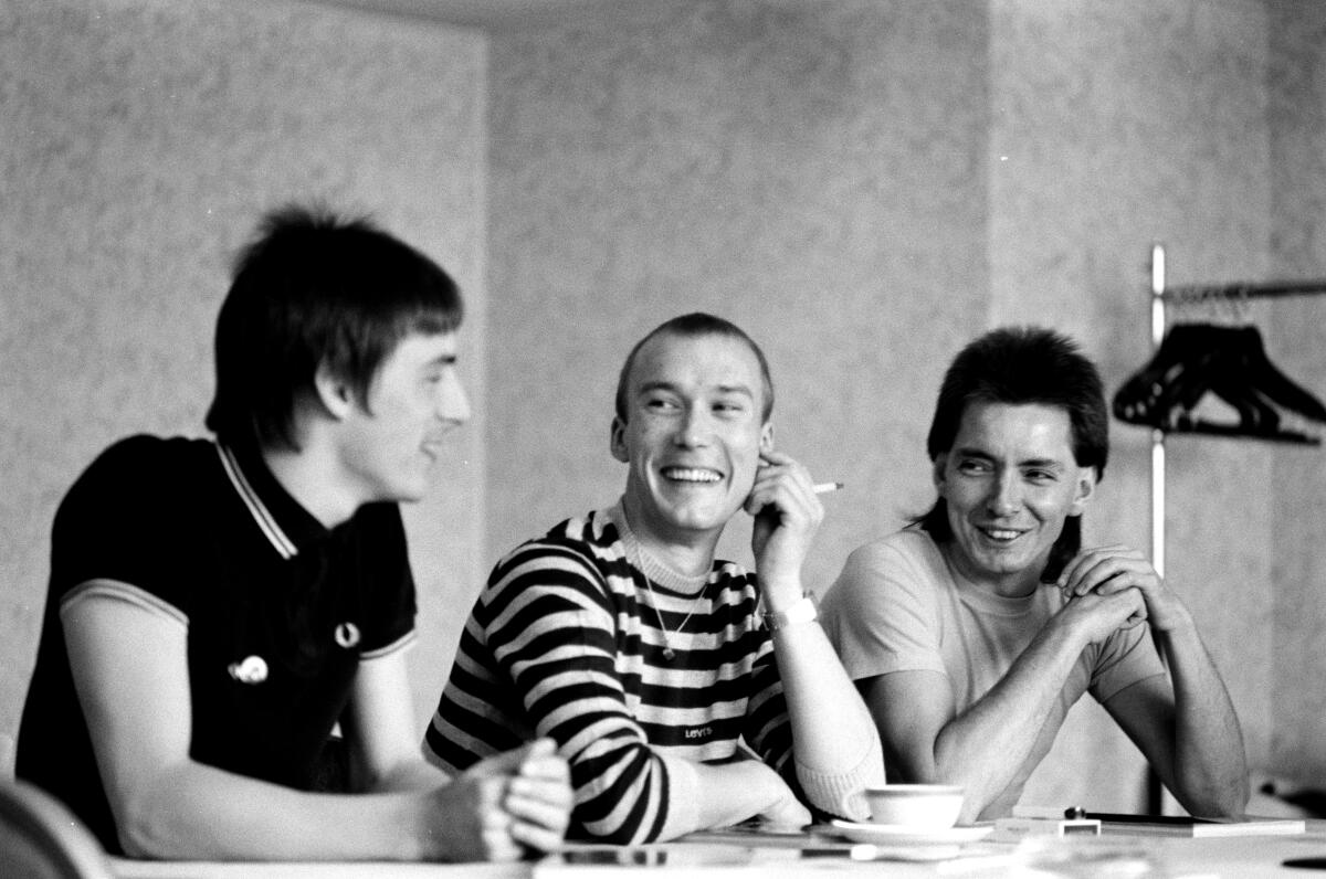 Black and white photo of the three members of the Jam sitting at a table in 1982