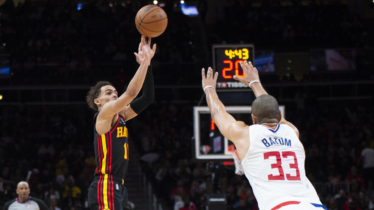 Atlanta Hawks guard Trae Young shoots a three-pointer over Clippers forward Nicolas Batum on March 11, 2022.